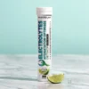 Pastilles Électrolytes FutureLab au citron vert, emballage vertical blanc et bleu, bouchon blanc, demi-lime verte et glaçons sur marbre.